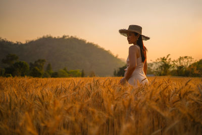 Rear view of woman standing on field