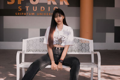 Portrait of young woman sitting on seat