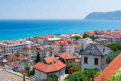 High angle view of townscape by sea against clear sky