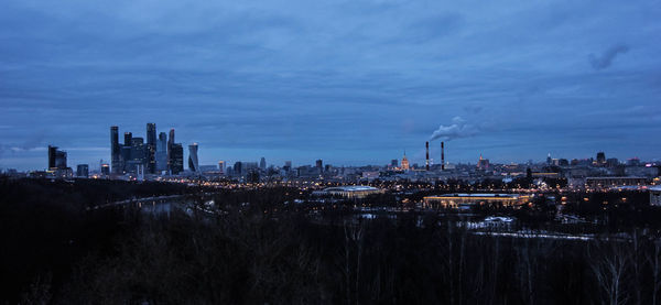 Illuminated cityscape against sky at night