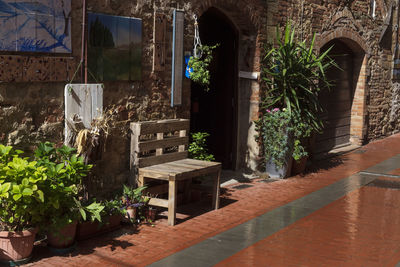 Close up of a bench against the wall ia a medieval street and art works hanging on the wall