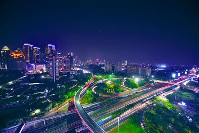 High angle view of illuminated city street and buildings at night