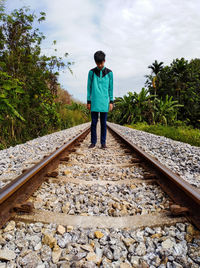 Rear view of man standing on railroad track