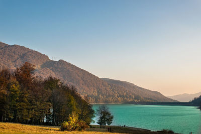 Scenic view of lake by mountains against clear sky