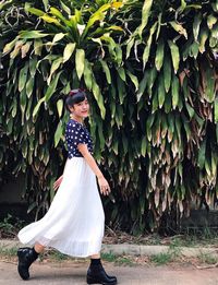 Side view of woman standing against plants