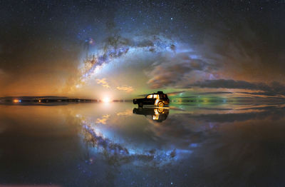 Amazing scenery of suv car parked on mirrored salar de uyuni salt flat reflecting spectacular starry night sky with glowing milky way galaxy in bolivia