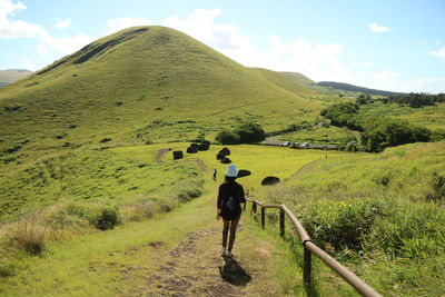 Female exploring puna pau crater, red scoria quarry for moai statues topknots, easter island chile