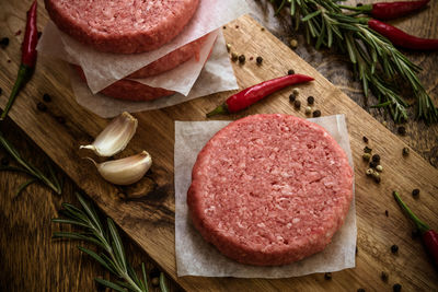 High angle view of minced meat with ingredients on cutting board