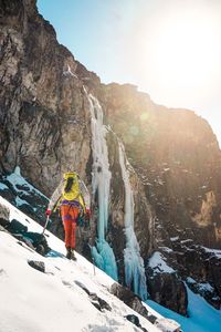 Rear view of hiker on snowcapped mountain