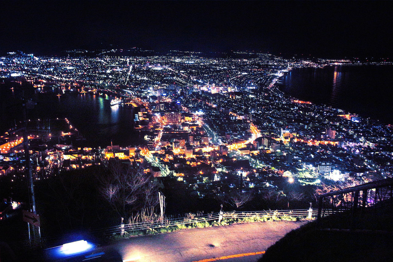 HIGH ANGLE VIEW OF ILLUMINATED BUILDINGS IN CITY