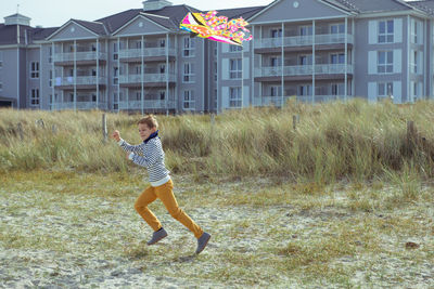 Full length of boy flying kite at beach