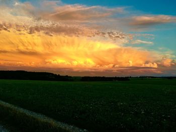 Scenic view of field against sky at sunset