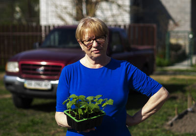 Portrait of young man standing against plants