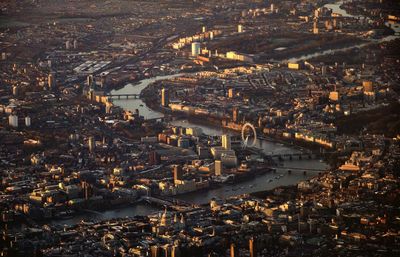 High angle view of illuminated city by river and buildings