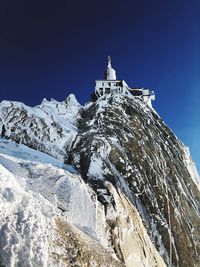 Low angle view of lighthouse against sky during winter