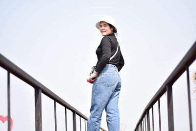 Portrait of a smiling young woman standing on staircase