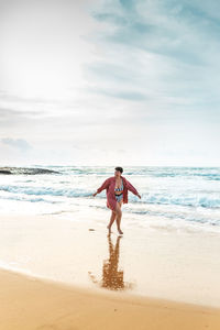 Full length of boy on beach against sky