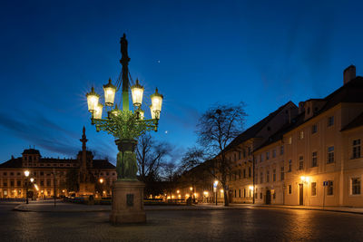 Illuminated buildings by gas street lamp in prague at night