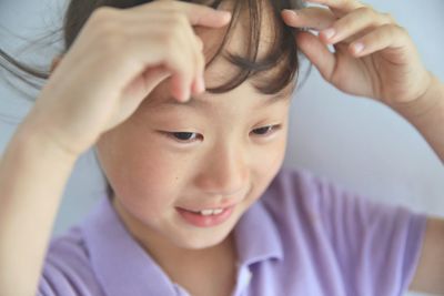 Close-up of cute girl touching hair