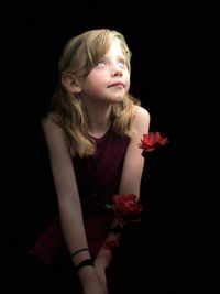 Low angle view of young girl against black background