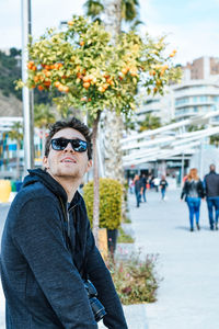 Close-up of man wearing sunglasses against trees