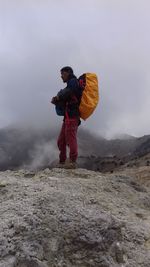 Full length of man standing on mountain against sky