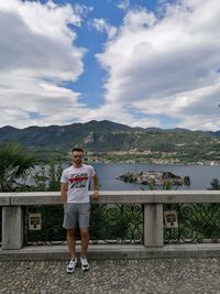 Full length portrait of man standing on mountain against sky