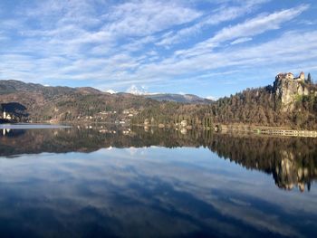 Scenic view of lake by mountains against sky