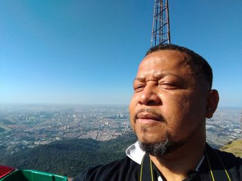 Mid adult man looking at cityscape against clear sky