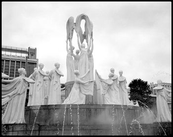 Low angle view of statue against building against sky