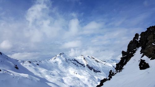 Low angle view of snowcapped mountains against sky