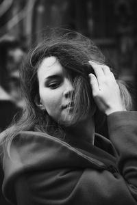 Close up positive woman adjusting hair on street monochrome portrait picture