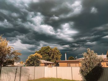 Storm clouds over plants and building against dramatic sky