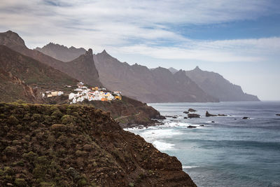 Scenic view of sea and mountains against sky