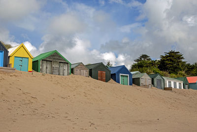 Huts on beach against sky