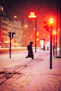 Rear view of woman walking on street at night