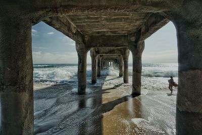 Man looking at sea seen through arch