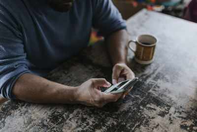 Man sitting at table and using phone