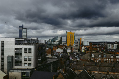Buildings in city against cloudy sky