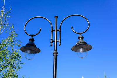 Low angle view of street light against blue sky