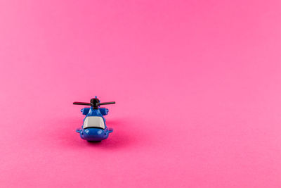 Low angle view of electric light against pink background