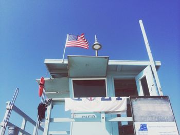 Low angle view of flags against blue sky