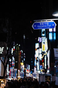 Illuminated sign on street in city at night