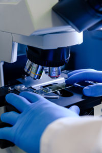 Cropped hands of scientist holding microscope slide