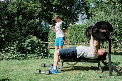 Two men working out together at a home gym in the garden