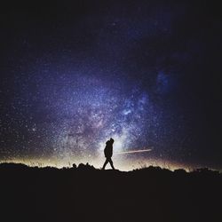 Silhouette of man with arms raised against sky