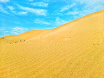 Sand dunes in desert against sky