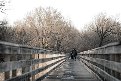 Rear view of woman walking on footbridge