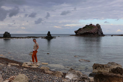 Scenic view of rock formation in sea against sky