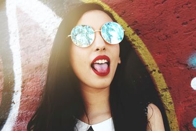 Portrait of young woman against wall